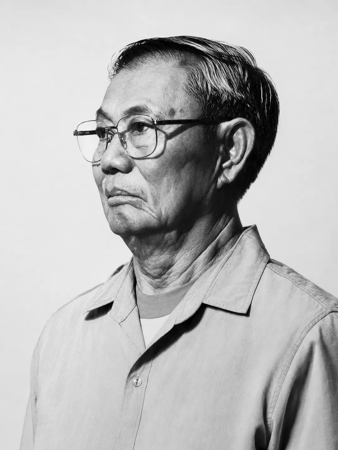 ภาพเหมือนลุงขาวในวัยผู้ใหญ่ ใส่แว่นตา มองไปด้านข้าง สื่อถึงบุคลิกมุ่งมั่นและพึ่งตนเอง